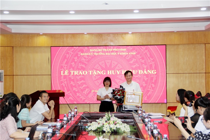 Bí thư Lê Thị Thanh Tâm trao Huy hiệu Đảng và tặng hoa chúc mừng đảng viên Nguyễn Trọng Tài