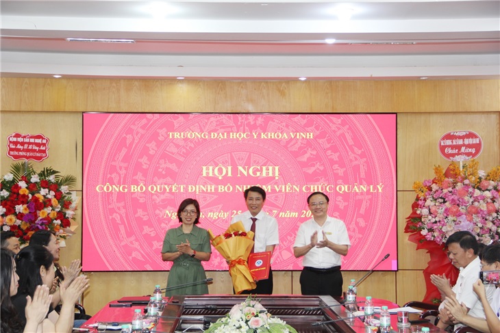 TS. Lê Thị Thanh Tâm - Bí thư Đảng ủy và PGS.TS. Nguyễn Văn Tuấn - Hiệu trưởng - trao quyết định bổ nhiệm và tặng hoa chúc mừng TS. Hồ Đăng Mười trên cương vị mới