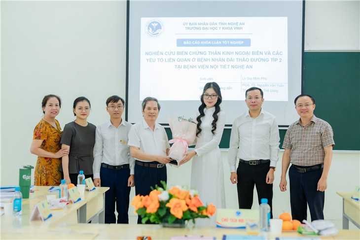 Thành viên hội đồng khóa luận tặng hoa và chụp ảnh lưu niệm với sinh viên vừa hoàn thành bài báo cáo