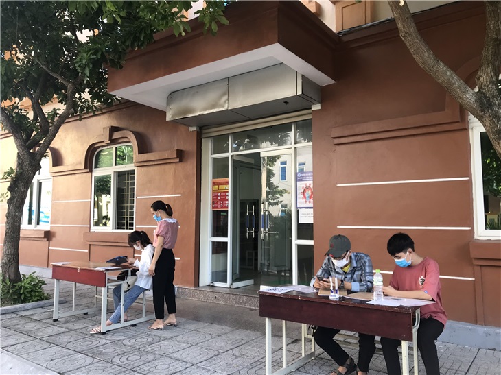 Cán bộ nhà trường hướng dẫn tân sinh viên đến làm thủ tục nhập học trực tiếp