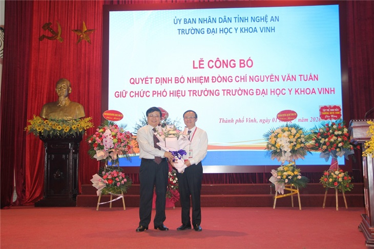 Đồng chí Bùi Đình Long - P.Chủ tịch UBND tỉnh Nghệ An - tặng hoa chúc mừng đồng chí Tân Phó Hiệu trưởng Nguyễn Văn Tuấn