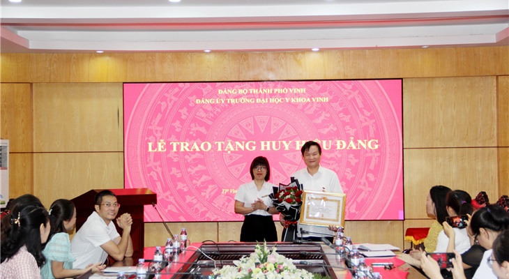 Bí thư Lê Thị Thanh Tâm trao Huy hiệu Đảng và tặng hoa chúc mừng đảng viên Nguyễn Trọng Tài